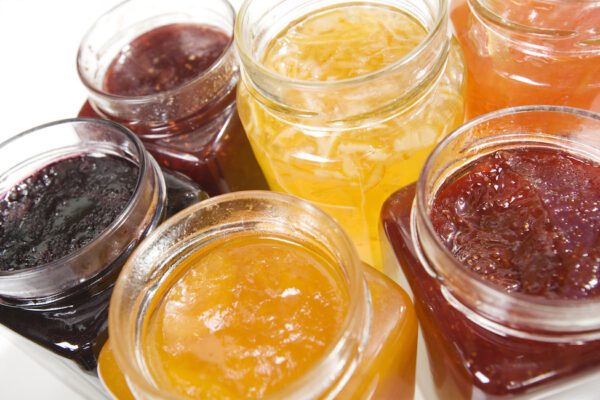 Six different varieties of jams in mason jars