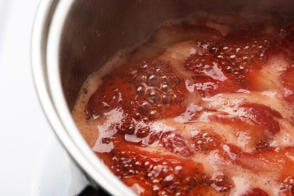 Strawberries boil in a pot